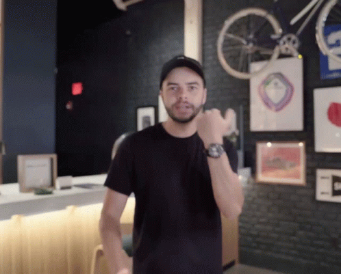Man Wearing Watch in Front of Bicycle Wheel
