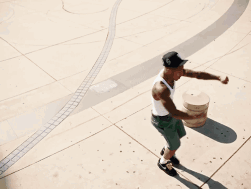 Man Wearing White Tank Top and Black Hat on Skateboard