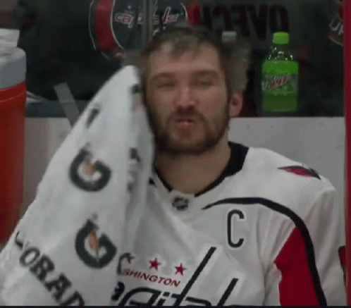 Man Wiping Face with Towel in Capitals Jersey