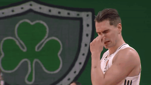 Man Wiping Nose in Front of Green Shamrock