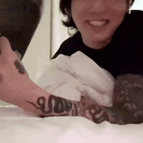Man With Arm Tattoo Laying In Bed With Woman GIF