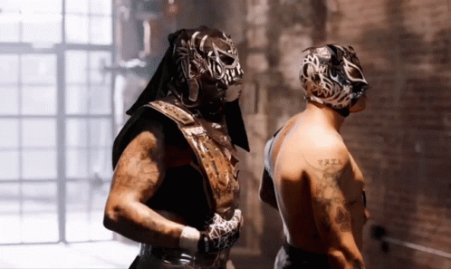 Man With Arm Tattoo Next to Masked Man