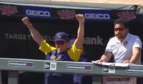 Man with Arms Up in Front of Geico Sign