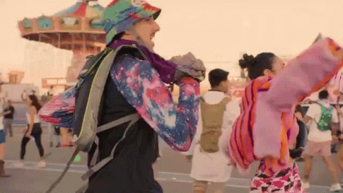 Man With Backpack Dancing At Amusement Park GIF