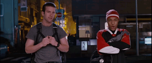 Man with Backpack Next to Man in Red and White Sweatshirt