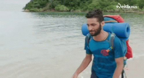 Man With Backpack Walking on Beach eitb.eus