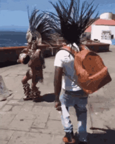 Man With Backpack Walking Past Native American GIF