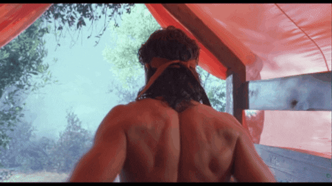 Man With Bandana In Front Of Red Tent GIF