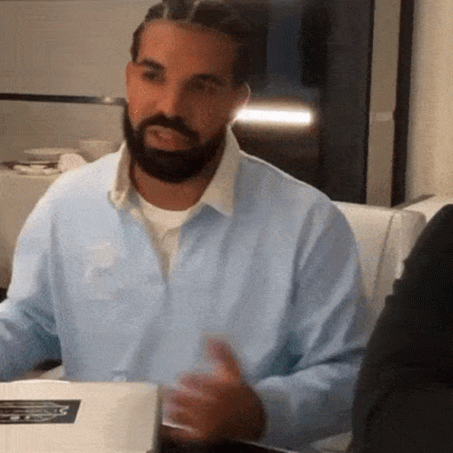Man With Beard And Braids Sitting At Table GIF