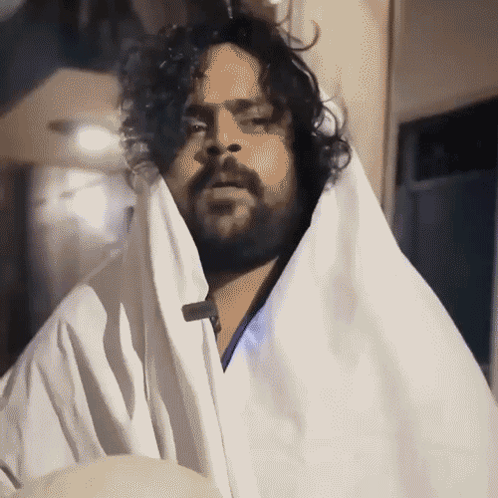 Man With Beard and Curly Hair in White Blanket