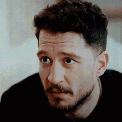 Man with Beard and Curly Hair Looking Serious