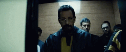 Man With Beard and Glasses in Elevator With Other Men