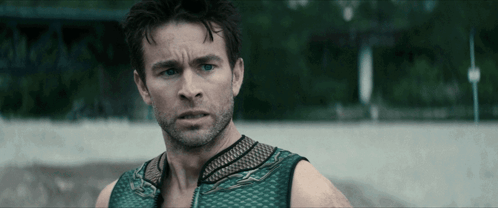 Man With Beard And Green Tank Top Looks At Camera GIF