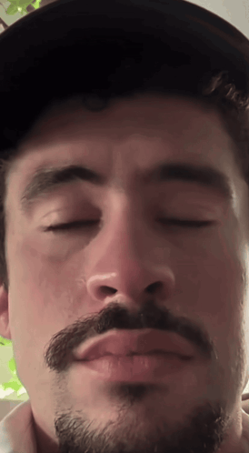 Man with Beard and Hat Making Funny Face Eyes Closed