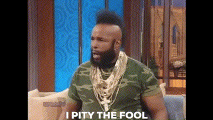 Man With Beard And Mohawk Sitting On Couch In Camo Shirt And Gold Necklaces GIF