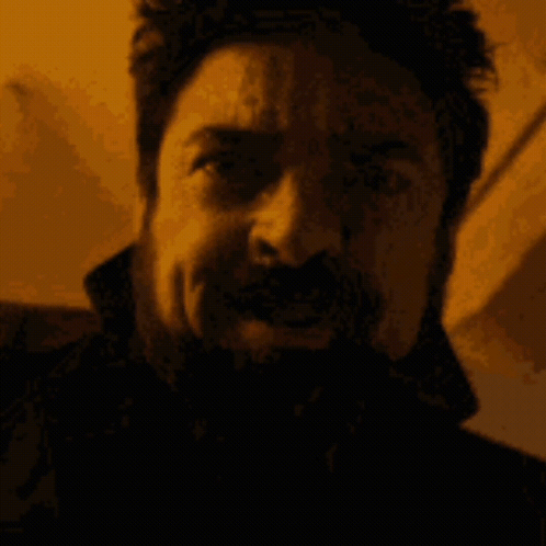 Man With Beard And Mustache Making Funny Face In Dark Room GIF