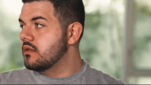 Man With Beard and Mustache Wearing Grey Shirt Making Funny Face