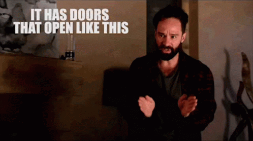 Man With Beard And Sign Saying It Has Doors That Open Like This GIF