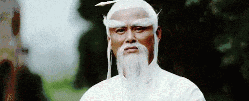 Man with Beard and White Hair in White Robe and Hat