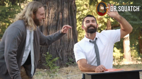 Man With Beard at Desk With Dr. Squatch Sign
