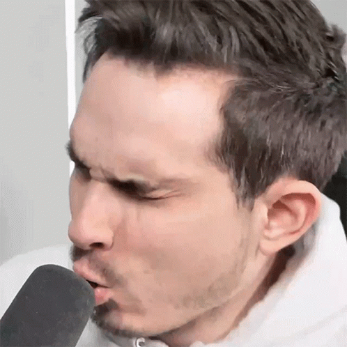 Man with Beard Blowing Into Microphone