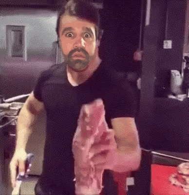 Man with Beard Holding Meat