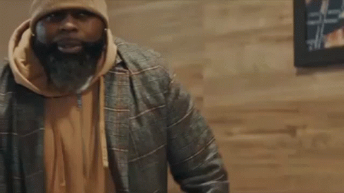 Man With Beard in Beanie and Jacket Talking to Another Man
