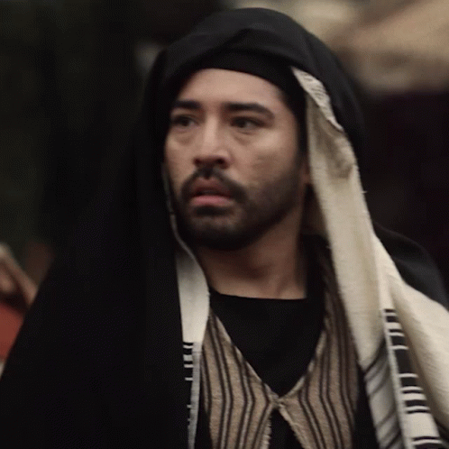 Man With Beard in Black Robe and Striped Vest