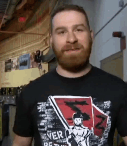 Man With Beard in Black Shirt Saying Never Be Stuck