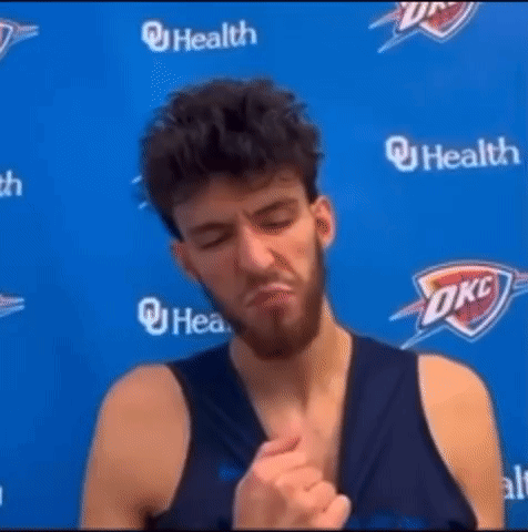 Man with Beard in Front of Blue OKC Logo