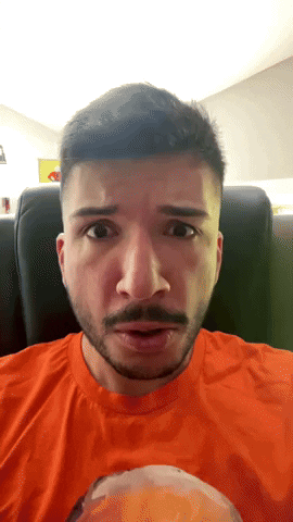 Man With Beard in Orange Shirt Looking at Camera