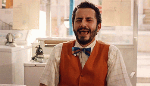 Man with Beard in Orange Vest and Bow Tie Laughing
