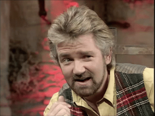 Man With Beard in Plaid Vest and Yellow Shirt