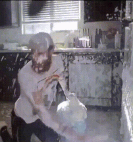 Man With Beard Kneeling In Kitchen GIF