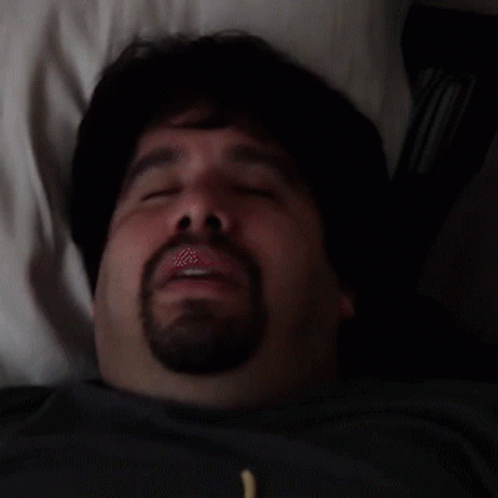 Man With Beard Laying in Bed Eyes Closed Mouth Open