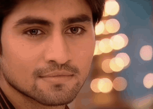 Man With Beard Looking At Camera Blurry Lights GIF