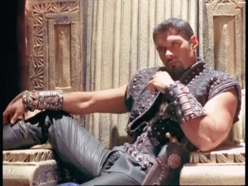 Man With Beard Sits on Throne With Sword