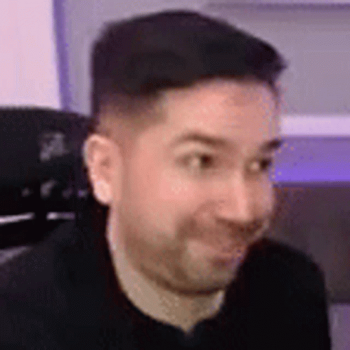Man With Beard Sitting in Chair Smiling