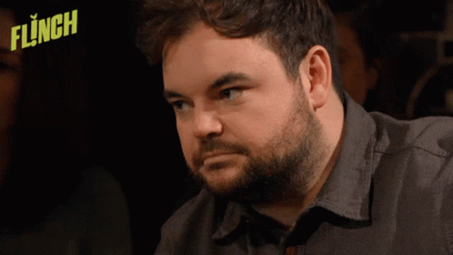Man With Beard Sitting In Front Of Flinched Logo GIF
