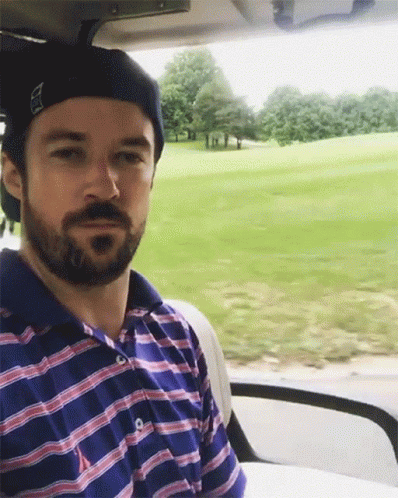 Man With Beard Sitting In Golf Cart Looking At Camera GIF