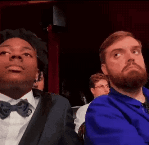 Man with Beard Sitting Next to Man in Blue Jacket