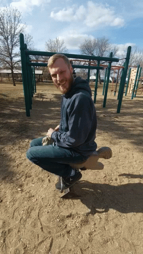Man With Beard Sitting on Seesaw at Playground