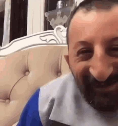 Man With Beard Smiling On Couch GIF