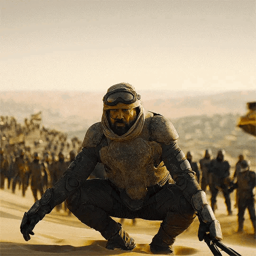 Man with Beard Squatting in Desert