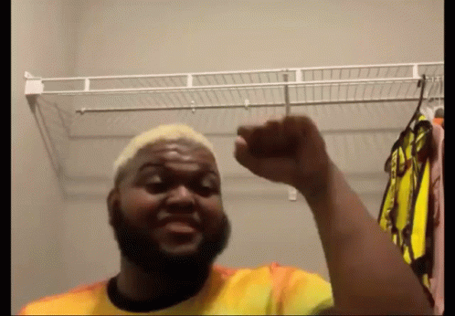Man With Beard Standing In Closet Fist Up GIF