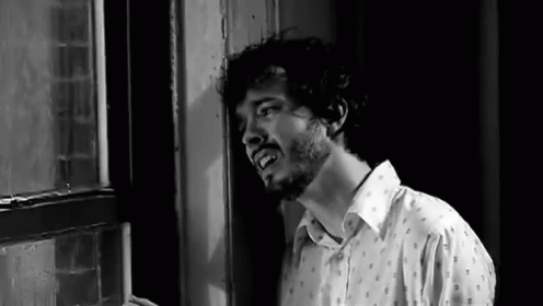 Man With Beard Standing in Front of Window
