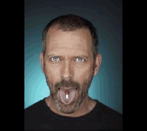 Man with Beard Sticking Out Tongue Holding Pill