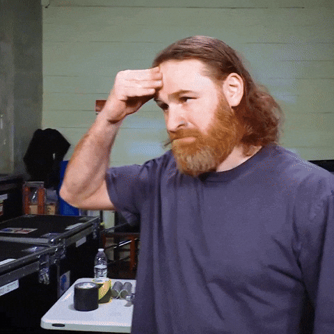Man With Beard Touching Forehead Gray Shirt