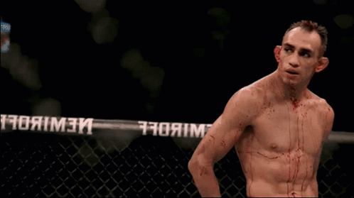 Man With Blood on Chest in Front of UFC Fence