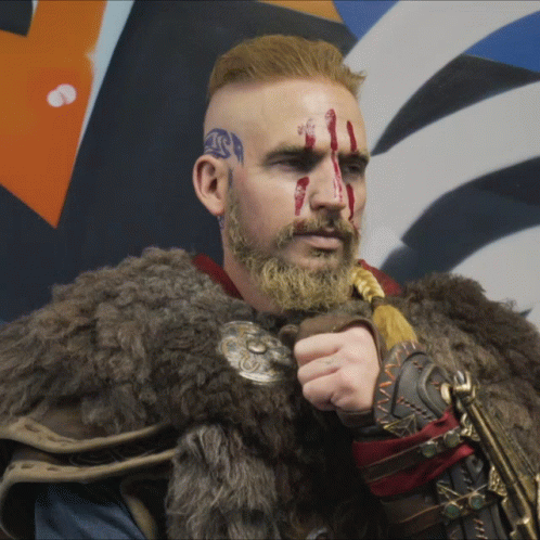 Man With Blood On Face And Beard In Fur Coat Holding Sword GIF